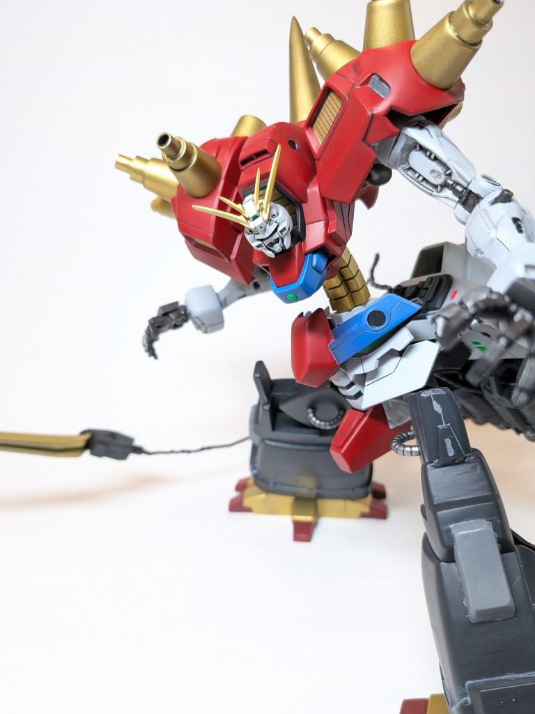 ［腰部分にあたる巨大ガンダムヘッドを隠すことで本来のデビルガンダムのもつ自己進化の力を抑制し、MFとしての出力を極限まで高めることが可能］「巨大ガンダムヘッドのアンテナがポージングの邪魔になるな…。思い切って取り外して尻尾にして攻撃しよう！ならいっそ、MF形態では顔も隠すか！」てなかんじでこの設定になりました。