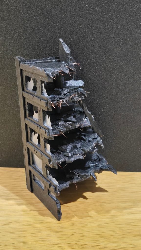 黒のカラーボードを、使って5階建てのビルを作りました。瓦礫はむしったカラーボードをボンド着けしました。