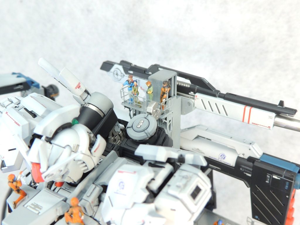 ■腕部　両肩アーマーはキットの可動機構を生かして、前後に開いた状態で固定しました。二の腕は左右で意識的にちぐはぐに装甲を取り外して、外観に変化を与えました。　右前腕部はハッチを切り欠いて内部メカが見えるようにし、左前腕部はビーム・サーベルが飛び出た状態で固定しています。腕のスラスターには、HIQPARTS製のφ1.5mmツインパイプ２シルバーを埋め込みました。ハンドパーツはビルダーズパーツの開いた状態のものを使用し、手の甲は開いた状態で固定しました。