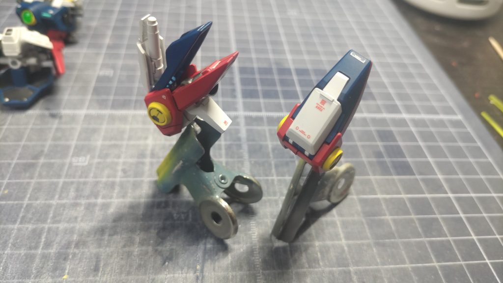 次に「肩部のビームサーベル収納ギミック」です。こちらもキットのままではサーベルを入れるスペースが無く「ビームサーベルを取り出す瞬間」みたいなシーンの再現は出来たのですが、実際には余りパーツとなるため、なんとしても収納がしたくなりました←こちらはシンプルに、サーベルがはみ出る長さ分のプラ(青パーツ)を削り込み、蓋をするように白パーツにプラ板を追加してサーベルの収納を可能としました。･･･とまぁ、文章で書くと一瞬のことのように思えるのですが、クリアランスの調整や、肩部の内側などについても実は細かい加工を施しているので、実際はこちらもかなり苦労し、手探りで徐々に進めて行きました。