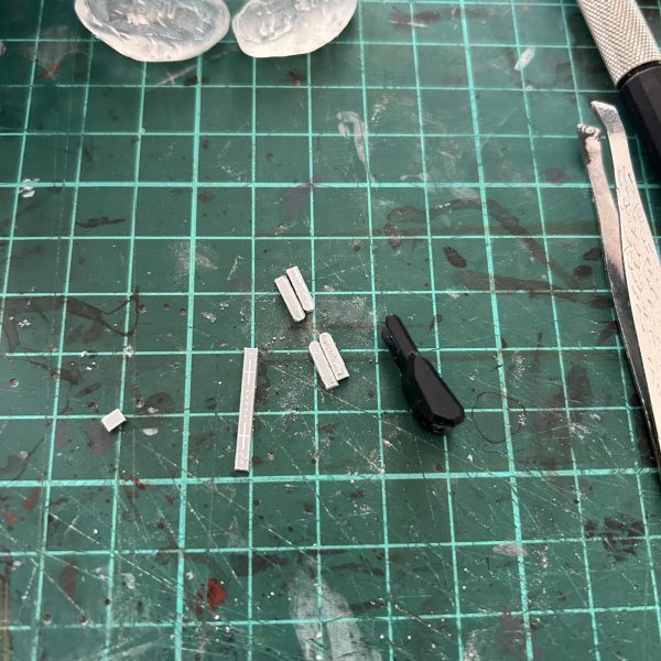 ついに手足が出来ました!(平手はやり直し)型を取り終わったものはハサミで細切りにして、また沸かしたお湯を入れれば、熱の通りも早くてすぐ次に使えます。同じパーツをまた作るにしても、前回の反省を踏まえてもう一度作り直した方が絶対上手くいきます。腕部装甲の突起部分はレジンだけではフニャフニャ曲がるだろうなと想像ついたので、レジンを流した型に形状を模したプラ板を差し込み。実験的な意図もありましたがしっかり一体化して固まってくれたので大成功です(^o^)平手のパーツがどうなるかなー?と思いましたが、指先に欠けが出ましたが意外と硬さもあって、型取りを工夫すれば次は上手くいきそうです。レジン使うときはビニール手袋とか指サックとか、レジン液が手につかないようにしましょう。最初素手でやってましたが、レジンアレルギーが〜とかじゃなく、石鹸でいくら洗ってもネッチョネチョ取れない!指に直でUVライト当ててパリパリ剥がす事になります。写真のビニール手袋は指先が余ってやりにくいですので、指先ぴったりのものがいいと思います。さあ後は股間サブアームとマルチコネクターポッドだ!(3枚目)