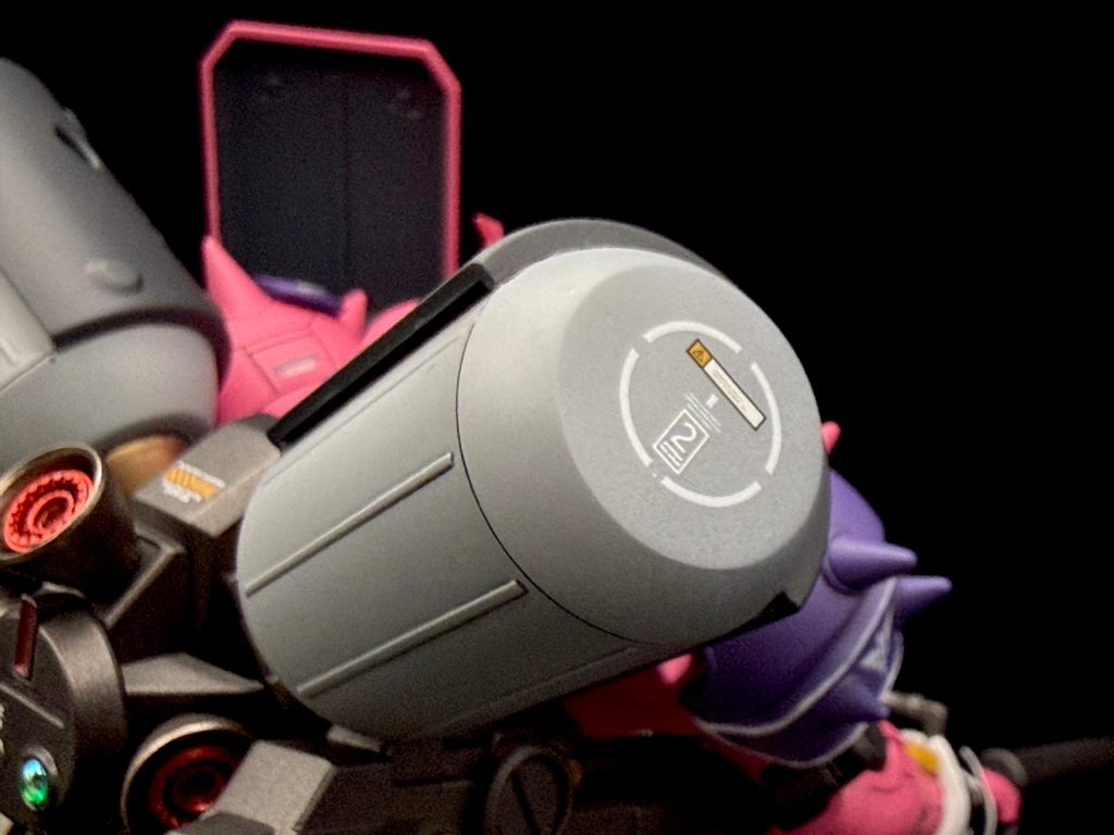 いつもと同様に、スジボリを軽く加え、紋章等にガンダムデカール（ユニコーン版、DXデカール）、コーション表示のために、ハイキューパーツのデカールやアシタのデカール、ロボデカールなどを使って、ディテールを追加各所に配置されたアポジモーターはキットをくり抜き、PLAISM FACTORYさんのレジンパーツに換装バーニアは、チキン屋楼さんのバーニアインナーを組み付けてありますまた、シールドの紋章は、デカールではなく、バンダイのエンブレムレリーフを貼り付けて、リアリティを上げてみましたその他の工作箇所はハイキューパーツの蛍光ピンクのドームにガイアノーツの蛍光クリアを上掛けしたものをモノアイ に貼り付け（これをするとブラックライト照射時も綺麗にピンクに発光してくれます）、シールドのアタッチメントをボールジョイント化して自由度を高めたぐらいです