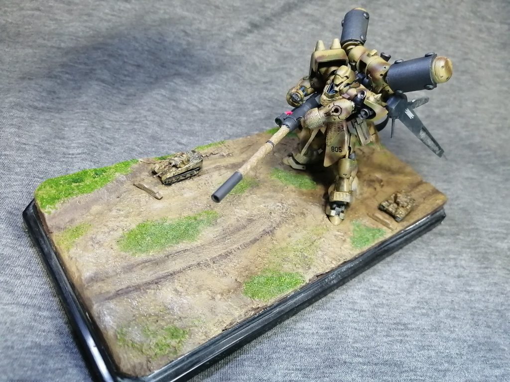 &nbsp;今回はヴィネットにする為、小物も作りました。　１円戦車とそこに付属してる小物です。　この１円戦車。縮尺が１/３５０で、ギラ・ドーガと大体合ってるのです。　タイガーⅠとパンター？レンガ壁に土嚢、ドラム缶、木箱ですね。　それぞれ塗装、タイガーⅠとパンター？はベースは№310をそのまま、ダークグリーンとレッドブラウンはギラドーガと同じです。　100均のディスプレイケースに造形粘土でベースを作り、これら小物とギラ・ドーガを配置。足跡やキャタピラの跡など付けてます。&nbsp;
