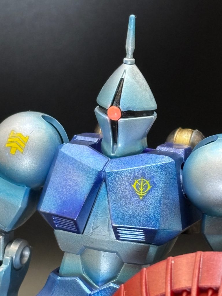 顔のアップモノアイのHアイズの裏に蛍光ピンクを塗って接着してます。胸部とスカートはガンダムメタバイオレット。金属の鋳造感を表現したくて、砂吹きして、敢えて塗りムラを狙ってみました。
