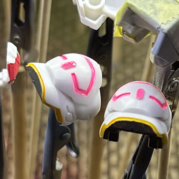 マジックリン洗浄を終えて乾燥させたので、部分塗装に入ります✨第2形態、第4形態の肩パーツ、脛、腰部の中央パーツをガンダムマーカーで、サイドアーマーをアクリルマーカーで塗り分けました。電源マークのモールドを蛍光色にしたいので、蛍光レッドを塗りたかったんですが、品切れ…😥替わりに蛍光ピンク塗ったら思いのほかピンクすぎて、何だかラーメンのナルトみたいやなぁ🍥とりあえずクリアパーツみたいにしたいと思い、UVレジンを流し込もうとする（また無謀なことを）こんな細いとこにどうやって…(gundam-kao1)爪楊枝でチョンチョンしてなんとか流し込んで、硬化させました。（あんまり見た目変わらないな💧）（4枚目）