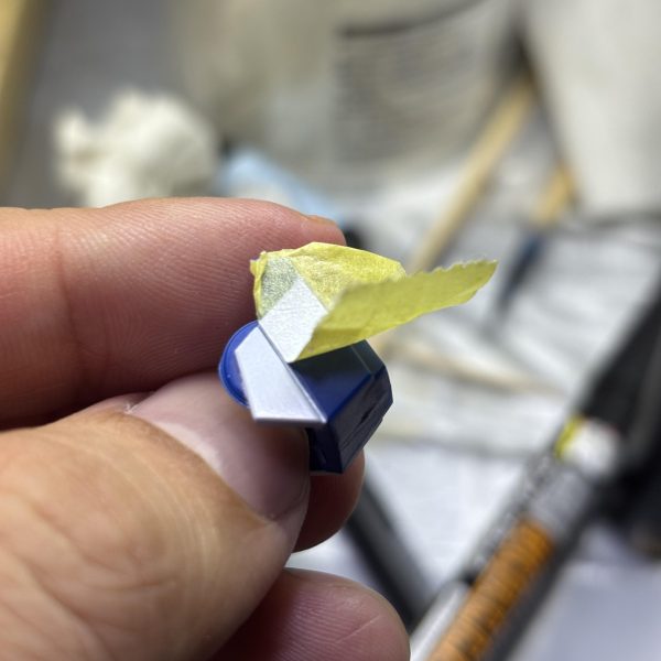 マジックリン洗浄を終えて乾燥させたので、部分塗装に入ります✨第2形態、第4形態の肩パーツ、脛、腰部の中央パーツをガンダムマーカーで、サイドアーマーをアクリルマーカーで塗り分けました。電源マークのモールドを蛍光色にしたいので、蛍光レッドを塗りたかったんですが、品切れ…😥替わりに蛍光ピンク塗ったら思いのほかピンクすぎて、何だかラーメンのナルトみたいやなぁ🍥とりあえずクリアパーツみたいにしたいと思い、UVレジンを流し込もうとする（また無謀なことを）こんな細いとこにどうやって…(gundam-kao1)爪楊枝でチョンチョンしてなんとか流し込んで、硬化させました。（あんまり見た目変わらないな💧）（2枚目）