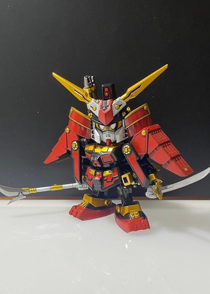 頭部はBB戦士。マスク部を切り離し顔のラインを変更して少し奥に入れ、眼を0.3mmプラ板で貼り付け。頭部と足以外はSDEXを使用し装飾などをプラ材で追加。薙刀と刀先端は真鍮線を埋め刺さるくらいに尖らせてます。胴体は切り刻んで接着しているので軽装タイプにはできません。