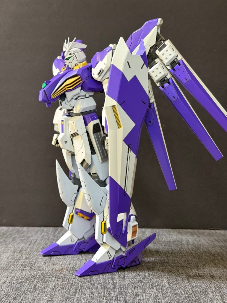 シン・フィン・ファンネル（SIN Fin Funnel）シン・νガンダム専用に新規開発された第5世代サイコミュ兵装。Hi-νガンダムに採用されたロングレンジ・フィン・ファンネルの発展型にあたり、従来機の長射程精密狙撃能力を継承しつつ、攻防両面において大幅な性能向上を果たしている。制御システムにはヘラクレスのヒュドラ•システムを搭載。内部フレームには最新世代の高効率エネルギー伝達システムと高感度サイコミュ・レシーバーを採用。ビーム収束率とジェネレーター出力効率が向上したことで、長距離狙撃時の威力・命中精度ともにロングレンジ・フィン・ファンネルを凌駕する。さらに、小型高出力スラスターと姿勢制御バーニアの追加により機動性能も飛躍的に向上。高速移動しながらの射撃や複雑な軌道制御を可能とし、敵の迎撃を回避しつつ多方向からの同時攻撃を実現する。防御面では、複数基を連結して展開することで強化型ビーム・バリアを形成可能。従来型より展開速度・耐久性能ともに向上しており、大出力ビーム兵器や多数の誘導兵器に対しても高い防御能力を発揮する。また、ヒュドラ•システムを搭載したことにより、シン・νガンダムに搭載された新型サイコミュシステムとの完全同期し、機体本体と一体化した戦闘制御を実現。遠距離狙撃、オールレンジ攻撃、広域防御を単一兵装で高次元に両立する、νガンダム系列サイコミュ兵装の完成形と位置付けられている。