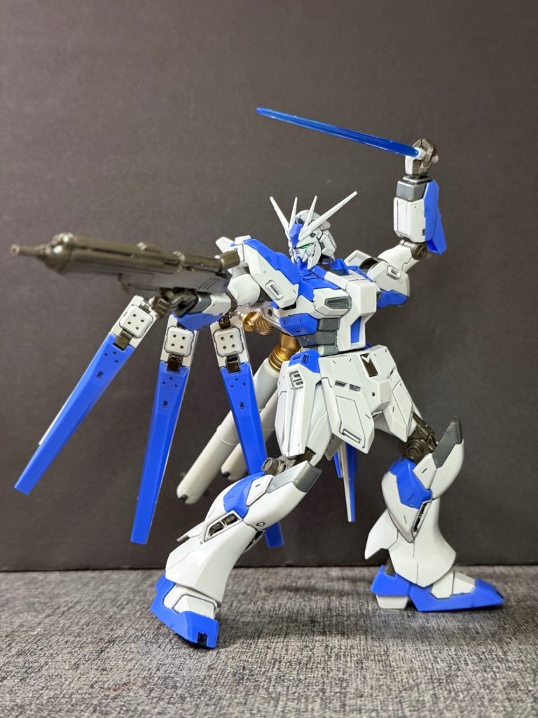【武装①】本機は長距離侵攻および単機での拠点防衛を想定し、内装・外装を問わず、兵装の出力向上と信頼性の確保が徹底されている。&nbsp;ビーム・ライフルとメガ・シールド： 銃身を延長し、収束率を高めた専用ビーム・ライフルを装備。シールドにはジェネレーター直結型のメガ粒子砲（またはミサイルランチャー）が内蔵され、攻防一体の運用を可能にしている。