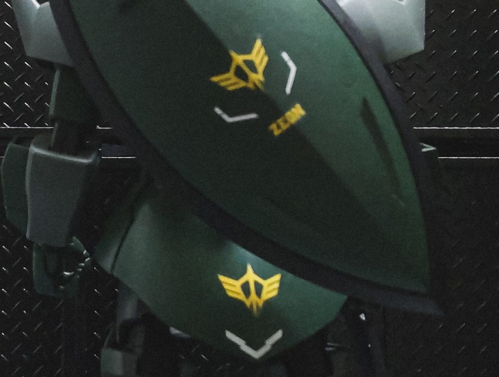 ↑ジオン突撃機動軍エンブレム　　　　　　「突撃機動軍」とはキシリア・ザビ少将が司令官を務めたジオン公国の軍事組織。グラナダに拠点を置き、ドズル・ザビ中将の「宇宙攻撃軍」と公国の戦力を二分する形で活動した。エース部隊や特殊な研究チームを擁しており、一説には