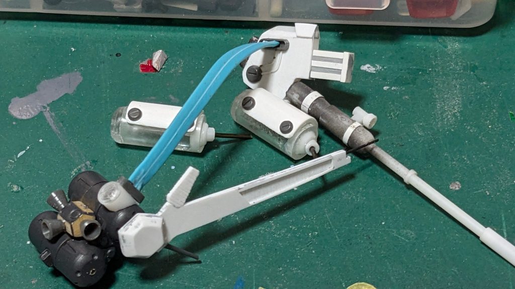 &nbsp;バックパック＆ランゲ・ブルーノ砲：　基本はそのままですが、大きな２つのタンクと放熱板？は自作しました。　下部、砲へと繋がる平ケーブルは壊れたイヤホンのコードです。基部は５ｍｍのプラパイプとMSGのマイナスモールドで追加しました。　中央のバーニアの数がノーマルとは異なるので切り離してMSGのバーニアに変えました。　タンクはバックパックの端の部分をUVレジンで複製。プラパイプと組み合わせてタンクを作り、１ｍｍプラバンで前方の装甲板を作りました。　放熱板はプラバンから、ランゲ・ブルーノ砲もプラバン、プラ棒、プラパイプ、MSGのマイナスモールド等でスクラッチ。砲身の布？はパテでそれっぽく。コードはリード線です。