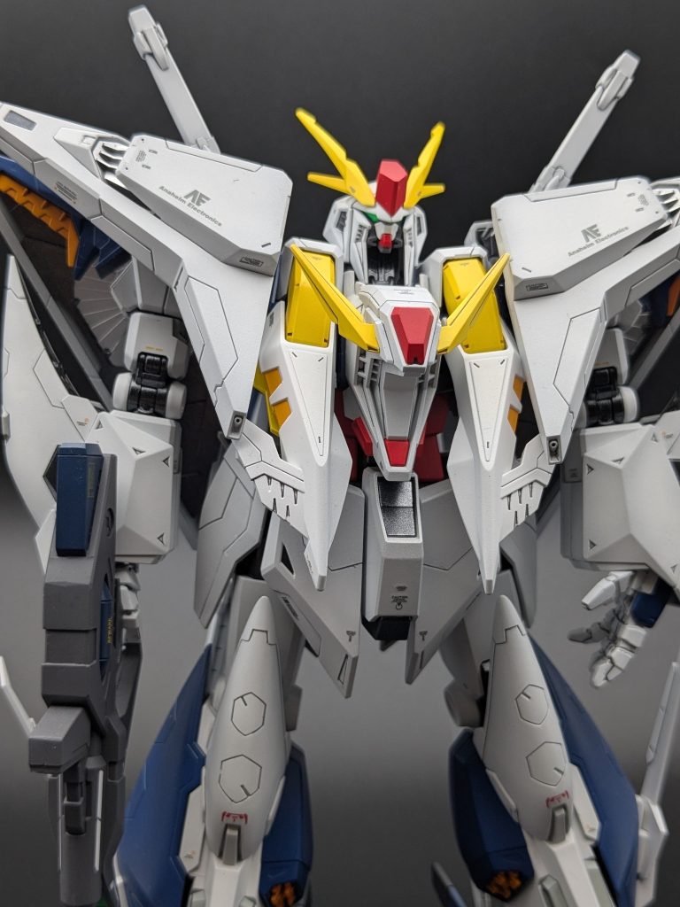 正面やや下から見上げた顔アップカット。カメラアイとV字アンテナの発色、フライトユニットの展開角度がよく見えるアングルです。