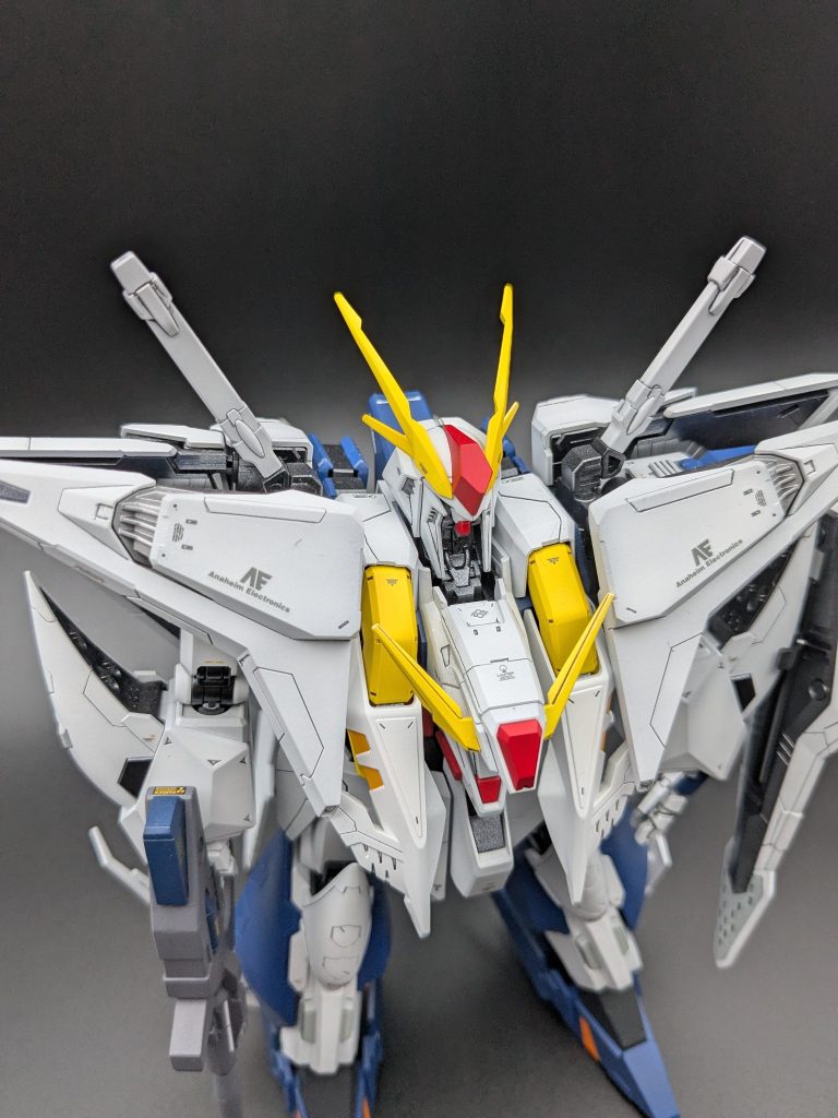 右前方上からフライトユニットの展開角度を捉えたカット。黄色パーツの塗り分けと「AE」デカールがよく見えるアングルです。
