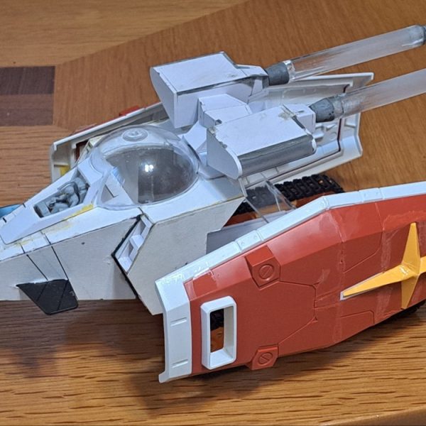 Gブルイージー軽装型のシールド支持部材作製しました。材料は2MM透明アクリル板です。この形態でのシールド支持構造は謎ですね。ガンダムがないのにシールド保持出来るんですから。これはミノフスキー粒子によりIフィールドを形成しXXXして空間にシールドを保持してると俺設定として、シールド支持部材の存在感を無くして透明アクリル板としました。端面はガラスヤスリで磨いてツルツルにしています。シールドは白い外周部と中央部を分割して、その中央部と赤い部品は裏面のリブやダボを削りまくって、2枚重ねでなるべく薄くなる様に加工しています。クローラーの配置は「Gブル」、「Gアーマー」、「Gファイター」、「Gファイター、Gアーマー飛行時の上半分収納」の4形態で変えています。Gブル時にはランドセルをクローラー間に落としこみ。ビームサーベルが当たるのでサーベル基部をHGと同様に折り畳み出来る様にしました。Gブルイージー軽装型の時にランドセルと干渉する部分が無くなるので、その部分を補完するパーツも作製しています。Gアーマー時には後方に移動、Gファイター時にはGパーツBの下に配置。(写真無し)Gファイター、Gアーマーの飛行時のGパーツBへのクローラー上半分収納ではクローラーのトレッド(？)を10mm短縮してBパーツ幅に収まる様にしています。(写真無し)（1枚目）