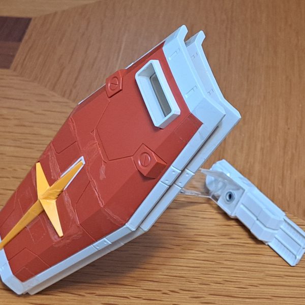 Gブルイージー軽装型のシールド支持部材作製しました。材料は2MM透明アクリル板です。この形態でのシールド支持構造は謎ですね。ガンダムがないのにシールド保持出来るんですから。これはミノフスキー粒子によりIフィールドを形成しXXXして空間にシールドを保持してると俺設定として、シールド支持部材の存在感を無くして透明アクリル板としました。端面はガラスヤスリで磨いてツルツルにしています。シールドは白い外周部と中央部を分割して、その中央部と赤い部品は裏面のリブやダボを削りまくって、2枚重ねでなるべく薄くなる様に加工しています。クローラーの配置は「Gブル」、「Gアーマー」、「Gファイター」、「Gファイター、Gアーマー飛行時の上半分収納」の4形態で変えています。Gブル時にはランドセルをクローラー間に落としこみ。ビームサーベルが当たるのでサーベル基部をHGと同様に折り畳み出来る様にしました。Gブルイージー軽装型の時にランドセルと干渉する部分が無くなるので、その部分を補完するパーツも作製しています。Gアーマー時には後方に移動、Gファイター時にはGパーツBの下に配置。(写真無し)Gファイター、Gアーマーの飛行時のGパーツBへのクローラー上半分収納ではクローラーのトレッド(？)を10mm短縮してBパーツ幅に収まる様にしています。(写真無し)（4枚目）