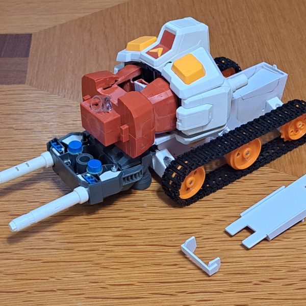 Gブルイージー軽装型のシールド支持部材作製しました。材料は2MM透明アクリル板です。この形態でのシールド支持構造は謎ですね。ガンダムがないのにシールド保持出来るんですから。これはミノフスキー粒子によりIフィールドを形成しXXXして空間にシールドを保持してると俺設定として、シールド支持部材の存在感を無くして透明アクリル板としました。端面はガラスヤスリで磨いてツルツルにしています。シールドは白い外周部と中央部を分割して、その中央部と赤い部品は裏面のリブやダボを削りまくって、2枚重ねでなるべく薄くなる様に加工しています。クローラーの配置は「Gブル」、「Gアーマー」、「Gファイター」、「Gファイター、Gアーマー飛行時の上半分収納」の4形態で変えています。Gブル時にはランドセルをクローラー間に落としこみ。ビームサーベルが当たるのでサーベル基部をHGと同様に折り畳み出来る様にしました。Gブルイージー軽装型の時にランドセルと干渉する部分が無くなるので、その部分を補完するパーツも作製しています。Gアーマー時には後方に移動、Gファイター時にはGパーツBの下に配置。(写真無し)Gファイター、Gアーマーの飛行時のGパーツBへのクローラー上半分収納ではクローラーのトレッド(？)を10mm短縮してBパーツ幅に収まる様にしています。(写真無し)（6枚目）