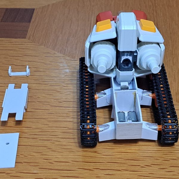 Gブルイージー軽装型のシールド支持部材作製しました。材料は2MM透明アクリル板です。この形態でのシールド支持構造は謎ですね。ガンダムがないのにシールド保持出来るんですから。これはミノフスキー粒子によりIフィールドを形成しXXXして空間にシールドを保持してると俺設定として、シールド支持部材の存在感を無くして透明アクリル板としました。端面はガラスヤスリで磨いてツルツルにしています。シールドは白い外周部と中央部を分割して、その中央部と赤い部品は裏面のリブやダボを削りまくって、2枚重ねでなるべく薄くなる様に加工しています。クローラーの配置は「Gブル」、「Gアーマー」、「Gファイター」、「Gファイター、Gアーマー飛行時の上半分収納」の4形態で変えています。Gブル時にはランドセルをクローラー間に落としこみ。ビームサーベルが当たるのでサーベル基部をHGと同様に折り畳み出来る様にしました。Gブルイージー軽装型の時にランドセルと干渉する部分が無くなるので、その部分を補完するパーツも作製しています。Gアーマー時には後方に移動、Gファイター時にはGパーツBの下に配置。(写真無し)Gファイター、Gアーマーの飛行時のGパーツBへのクローラー上半分収納ではクローラーのトレッド(？)を10mm短縮してBパーツ幅に収まる様にしています。(写真無し)（7枚目）