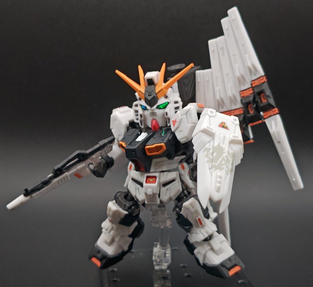 メラミンスポンジでツヤを抑え、ガンマカとポスカ（オレンジ）、水性ホビーカラー（黒）で部分塗装しています。スミ入れはコピックライナーです。ポスカは発色サイコー（顔料が濃い？）なのですが、プラに塗った場合は塗膜がとにかく弱いです。自分はポスカを塗った部分にガンマカのツヤ消しクリアをチョンチョンと直塗りして対応していました。多少はマシになります。第2弾が発表された時は、「目が変に離れてる…カッコ悪い」と思ってスルー。その後の弾以降は気に入ったものだけ購入していました。SP弾発売の頃はモビジョが継続して発売していた事もあり、せっかくだし買ってみるか〜と手に取ってみました。弄りながら見慣れてくると顔も「悪くないかな」と思えてきました😅