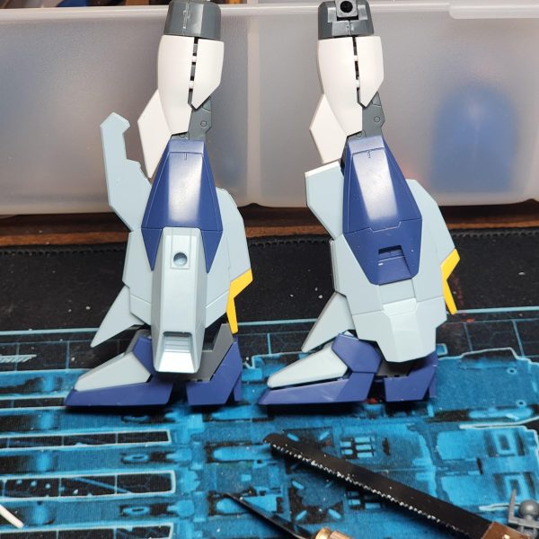 次のプロジェクトでは、「最高にカッコいい」ライトニングガンダムを作ることを目標に、カスタマイズを行っていきます。まずは脚部の延長から始めます。太もものパーツには「ガンダムAGE-IIマグナム」のものを使用しました。ただ、膝周りでパーツ同士の干渉があったため、その調整が必要でした。そこで、パーツをカットして中央で接合し、できた隙間をプラ板で塞ぐ方法をとりました。仕上がりには大満足です。膝の装甲が力強く、印象的な見た目になったと思いませんか?-For my next project I'll be customising a Lightning Gundam with one goal in mind, make it as cool as hell. Here I start with extending the legs. I added some thighs from Gundam Age II Magnum. There were some conflicting parts around the knee which I had to sort. I opted to cut the parts and make them meet in the middle and covered the hole with plastic. I am super happy with the results. The knee cap looks powerful and striking doesn't it? (2枚目)
