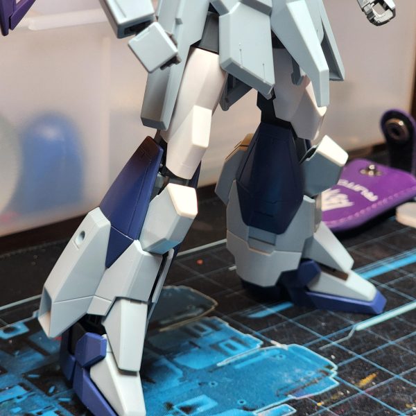 次のプロジェクトでは、「最高にカッコいい」ライトニングガンダムを作ることを目標に、カスタマイズを行っていきます。まずは脚部の延長から始めます。太もものパーツには「ガンダムAGE-IIマグナム」のものを使用しました。ただ、膝周りでパーツ同士の干渉があったため、その調整が必要でした。そこで、パーツをカットして中央で接合し、できた隙間をプラ板で塞ぐ方法をとりました。仕上がりには大満足です。膝の装甲が力強く、印象的な見た目になったと思いませんか?-For my next project I'll be customising a Lightning Gundam with one goal in mind, make it as cool as hell. Here I start with extending the legs. I added some thighs from Gundam Age II Magnum. There were some conflicting parts around the knee which I had to sort. I opted to cut the parts and make them meet in the middle and covered the hole with plastic. I am super happy with the results. The knee cap looks powerful and striking doesn't it? (3枚目)
