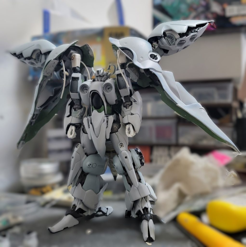 まだだ! まだ終わらんよ!バインダー開口。バインダー終端にプラバンを貼ってみた。肩関節二重化。腕を横に上げる時は、バインダー接合部とは独立して動きます。各所のカクカクしているところ、スポンジやすりで削って丸く。肩だけやり忘れた。その他、クシャトリヤにあって、クィンマンサに無い意匠をカット。<塗装>バインダー: 大理石塗装。クレオス クロームシルバー2 + クレオス クリアブルー + 適当に破った不織布ウェットティッシュでマスキング + クレオス クロームシルバー2 + 不織布を剥がして細かい繊維を頑張って取る + クレオス クリアピーコックグリーン緑色: キャンディ塗装。クレオス クロームシルバー2 + クレオス クリアピーコックグリーン黄色: クレオス クロームシルバー + クリアイエローとレッドを調色したもの黒色: クレオス 黒鉄色 + クリアブラックと光沢クリアとつや消しクリアを調色したものグレービング: エレガントカットシール仕上げ: 東邦産業 ウレタンクリアEX。見ての通り、テカテカド派手仕上げになりました。