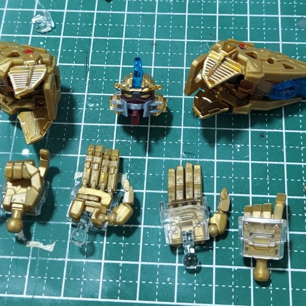 完成と云ってもフレームの話です。頭部と肩部を作り、両腕、胸部と合体。頭頂と肩のスラスターはクリアーパーツをクリアーブルーで塗装しています。半光沢のトップコートを吹いたら少々くすんでしまったので、やはりクリアーパーツには光沢の方が良さそうです。ツインアイはゴールドとクリアーの選択式になっています。額のセンサーの下段は、貼ろうとしている間に失くなってしまったので、メタリックシールの余剰部分を使って貼っています。少し面積が大きくなっても粘着力の弱さは変わらないので、その後は最初からタミヤセメントを使って貼っています。十分に乾かす時間が必要となるため、作業が中断せざるを得ないのはもどかしいところです。ついでにハンドパーツをまとめて製作しました。可動指は曲げようとするとやはりポロポロと外れてしまいますが、ビームサーベルを持たせられるのはこの可動指の付いたハンドだけなので、作らないわけにもいかず。平手が付いているのはいいですね。 (2枚目)