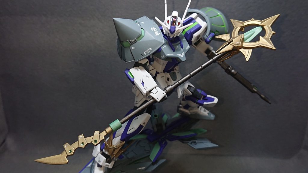 メイン武装は、30MFの余りパーツで作ったオリジナルの“ロッド”になります💡近接武装をロッドにしたのは、飛び回りながらの攻撃にはリーチの長さがあった方が活きるかなって思ったのと、良い感じの武器がたまたま出来たのでどうしても使いたかったからですねｗこういうオリジナル武装がたまたま出来ると優先的に使いたくなっちゃうのが自分の悪い癖です✨この武装は先端の形状が異なっており戦況に応じて使い分けることを想定しています突起がたくさんあり重そうな方は打撃用で、すれ違いざまに重たい1撃を入れて敵の装甲や盾などを破壊する感じです！頭部を叩き潰すシーンとか迫力があって格好良いですよねｗ刃の方は突きや斬撃用で、関節や武装を狙い機動力や攻撃力を削ぐ様な使い方を考えています！デザインにも少し拘っており、装飾品として100均で購入した“ライトストーンパーツ(黄緑)”を6つ埋め込んでみました✨結構いい感じになったので、今後のストライク改造にも取り入れていきたいですねｗ