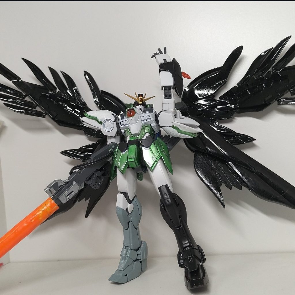 原作準拠ショット。アイコンからもわかる通り、じぶん東方の霊烏路空ってキャラがすきなもんで、ウイングゼロ買ったときに閃いてしまったんです。「そうだ、まんま空にしよう！」SEは勿論ニュータイプのアレです。先にバスターライフルの解説していきます。元の霊烏路空も制御棒という名のシングルバスターライフルを持っているので、こちらも2挺から1挺へと変更。銃身の下のはみ出てるやつをカットしてグロックバレルをはめれるようにします。グロックバレルとは、ぶっ壊れた10禁電動ガンのグロックから自分がサルベージしたバレル部分のことです。金属パーツなのでガンプラにとってはなかなか重く、片手で水平に保たせることは不可能です。ってことで、サムネみたいに肩に掛けるのが無難な飾り方となってます。照準器は元の位置だとグロックバレルに干渉してしまうので、中の板？と後ろの突起を切り詰めて配線に被せました。余ったもう1挺と噛み合わせる為の溝からグロックバレルの下へ、銃身を一周這う感じにコードを繋げて、核エネルギー伝わってそう感を倍増させました。
