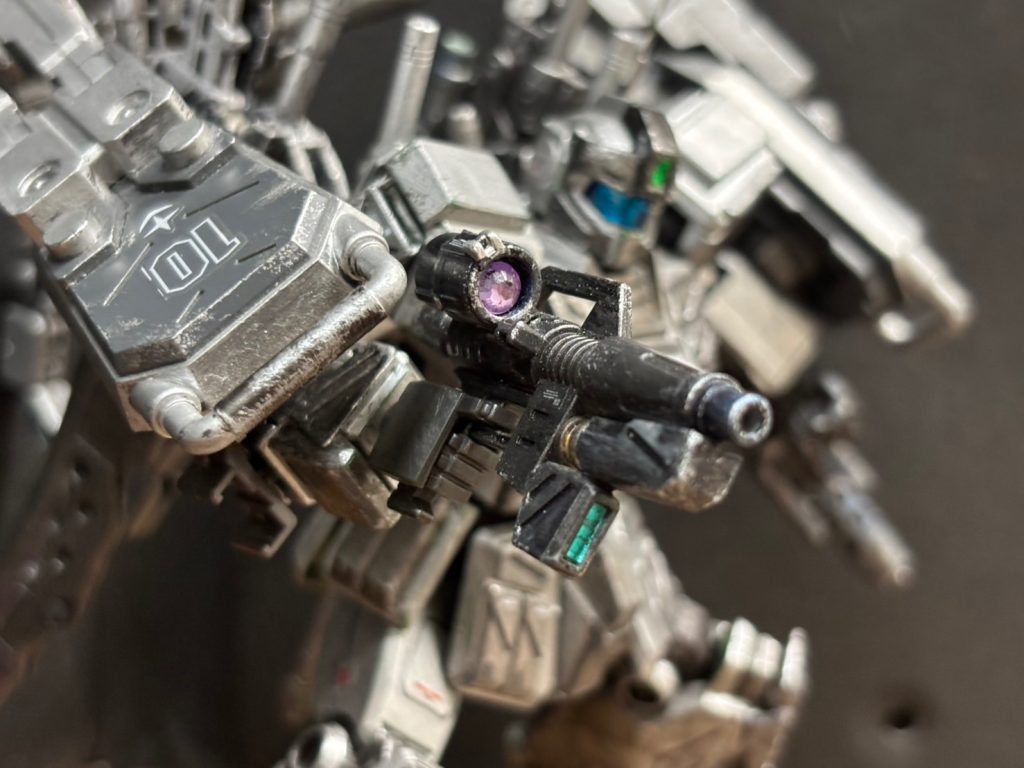 8. ビームスプレーガン［改修型］&nbsp;連邦軍標準のビーム・スプレーガンをベースに、至近距離での絶対的な一撃必殺能力を追求。エネルギーの収束率と出力を限界まで引き上げる近代化改修が施されている。これにより、原型機のような「光条の拡散」は完全に抑え込まれ、ピンポイントで敵の最重装甲（コックピットハッチや駆動ジェネレーター）を融解・貫通する高出力精密な物へと生まれ変わった。普段は右脚側面に堅牢にマウントされている近接戦用のビーム兵器。片腕のグラップシールドで敵MSを強引に壁面へ押し付け、あるいは片アーム単体で敵をガッチリとホールドして動きを封じた最中に、もう片方の空いた腕で右脚からこの銃を電撃的に引き抜いて使用する。グラップシールドのすぐ隙間から、身動きの取れない敵の急所へこの高収束ビームを直接叩き込み、分厚い装甲ごとコックピットを撃ち抜いて確実に息の根をとめる。