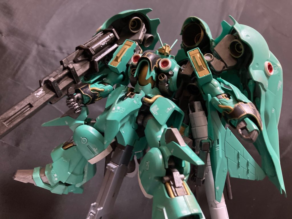 設定:ネオ・ジオン軍（袖付き）が開発した試作型モビルスーツ。クインマンサの量産を視野にいれたニュータイプ専用機で、コクピット周辺へのサイコフレーム搭載によるサイコミュシステムの小型化と複数の機能を集約したファンネルバインダーを2枚から4枚に増加させた事により、原型機の性能を維持しつつ20m級へのダウンサイジングに成功している。あらゆる可能性を視野に入れ、巡航形態であるエルメスⅢへの可変を可能にしている。後に連邦の象徴であるガンダムヘッドはジオン系ヘッドに変更され、可変は省略、背面のファンネルバインダー配置が悪く、射出時に機体本体と干渉を起こしやすかったため、後に肩部4枚へと改められ、機体の複雑化を招く可変機構はオミットされた。