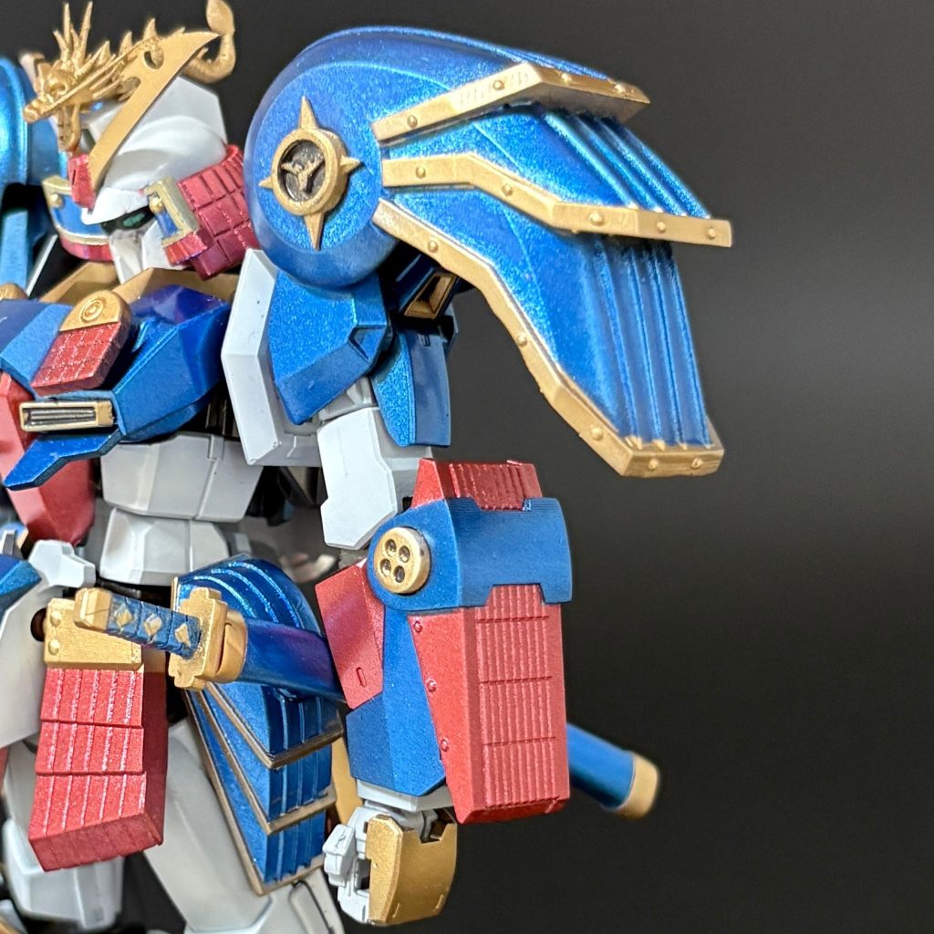 肩アーマーや、手甲、刀などをご覧ください。大きな家紋は別パーツで後ハメしています。家紋のデザインは武者Zのクワガタを模したものですが、小さくて見えませんね^^;これらもマスキングによる塗分けのほか、刀の柄などあまりに細かい箇所はエナメル塗料で塗分けています。