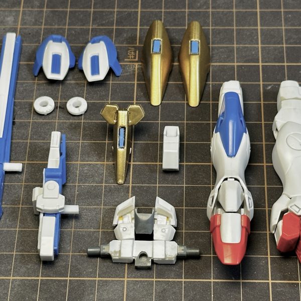 続いてV2ボトム・ファイターV2コア・ファイターとボトム・リムに分離可能ボトム・リム基部は、V2ガンダム胴体の胸部前面を切り離してプラ板を軸に整形股関節は左右に切り離して固定脚部は腿の回転軸をオミットして合わせ目消し踝のアーマーは一体化していたものを左右と後ろを切り離して脛側に接着靴は折り畳み後の形状がなるべく薄くなるように前後を切り離して整形足裏の肉抜き穴埋め腰部はノーマル状態とアサルト状態を差し替えできるよう基部をプラ板で自作アサルトパーツのメガ・ビームライフルは、バレルユニットとコントロールユニットでそれぞれ折り畳み状態固定コントロール側の側面はほぼ肉抜き状態なのでプラ板で補完(5枚目)