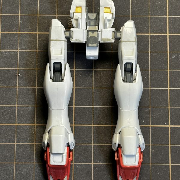 続いてV2ボトム・ファイターV2コア・ファイターとボトム・リムに分離可能ボトム・リム基部は、V2ガンダム胴体の胸部前面を切り離してプラ板を軸に整形股関節は左右に切り離して固定脚部は腿の回転軸をオミットして合わせ目消し踝のアーマーは一体化していたものを左右と後ろを切り離して脛側に接着靴は折り畳み後の形状がなるべく薄くなるように前後を切り離して整形足裏の肉抜き穴埋め腰部はノーマル状態とアサルト状態を差し替えできるよう基部をプラ板で自作アサルトパーツのメガ・ビームライフルは、バレルユニットとコントロールユニットでそれぞれ折り畳み状態固定コントロール側の側面はほぼ肉抜き状態なのでプラ板で補完(3枚目)