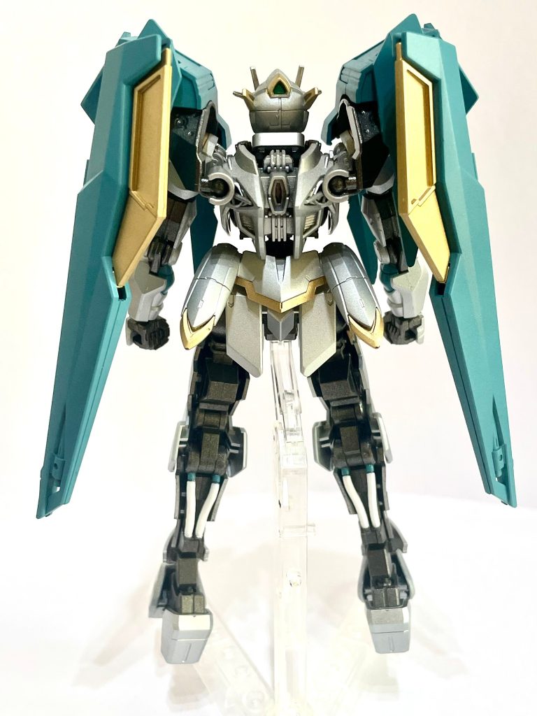 翼状肩部バインダー《ベルシラック》両肩から背部に展開する大型複合兵装。巨大な翼のような形状を持つが、実際には複数の装甲板、推進器、姿勢制御装置、エネルギー伝達機構を組み合わせた多目的ユニットである。通常時は肩部を覆うことで大型の肩装甲として機能する。戦闘時には左右へ展開することで推進器を露出し、機体の姿勢制御能力を向上させる。さらに装甲板そのものを可動させることで、敵からの攻撃に対して即座に防御姿勢を取ることが可能。