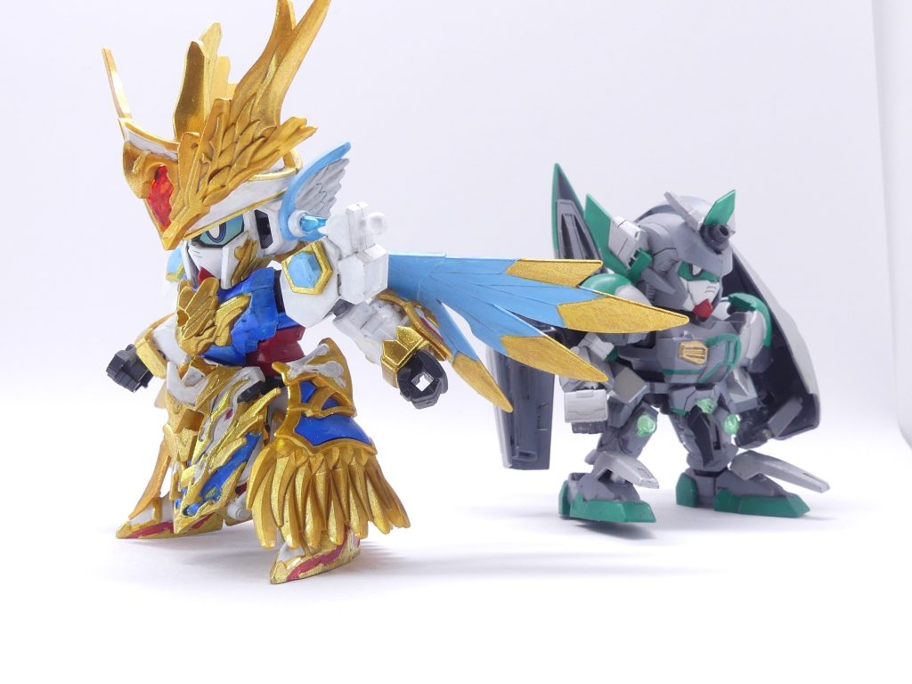 そのガンプラに対し、王様は「決闘」･･･１対１のバトルという形で事を収めることにしたのですが･･･なかなか上手くいっていません。つい先日は、エバーランド自警団の一人・ガンサンダーもやられてしまったそうです。ヴァトラス城に、これ以上の騎士はいませんでした。アマミチ達は今も重傷の彼らに代わって、「エバーブック」の所持者として彼と戦うことになってしまったのでした。相手はディランザの改造ガンプラ。まさに「水星の魔女」のごとしです。･･･数日後、アマミチはイルマ先生にこう述べました。「ガンダム世界はフィクションですが、僕らがガンダムパイロットになれなくても･･･今だ戦争や紛争の続くこの世界のために考えることはいっぱいあるはずです！」意外と社会派な答えは、先生の心を動かし･･･すっかり、受け入れられてしまいました。イルマ先生は顧問となり、「ガンプラ部」は始動しました。もちろん、先生には「エバーランド」の事をきちんと話した上で了承を得ました。先生の仕事が無いときは放課後に付き添ってくれることになったのですアマミチ達はエバーランドへの「入り口」を。「エバーブック」は、新たな「読み手」を得たのです･･･（次回を待て！）