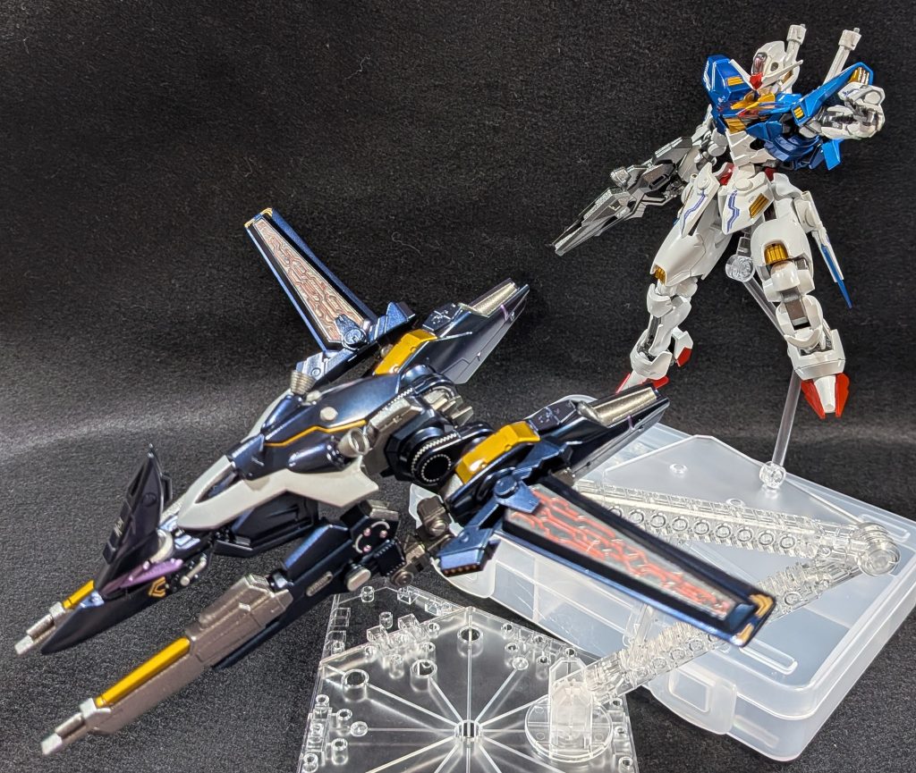 【パーメットブースター】ミラソウル社製フライトユニットをベースに、ガンプラの余剰パーツなどを再利用して作成。本体から分離し、独立飛行が可能な支援機です。ウィングにはパーメットのパターンを彫刻し、クリアのプラ板でカバーしてあります。機首はWガンダムのシールド（フェニーチェの余剰）を元に作成。頭に付いている三角のパーツはMG戦国アストレイの余剰。その後方に専用のシールドブースターをマウントしています。（LBXアキレス・ディードの盾を改造して作成。）2つ突き出たツインキャノンはパワアムの物をベースに改造。先端の銃身を切り飛ばし、代わりに四角い銃口に作り変えました。カラーリングはWゼロのツインバスターライフルを意識しています。