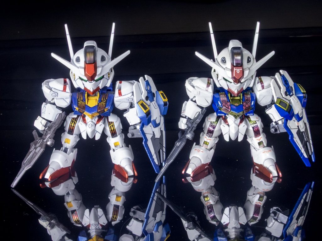 過去に製作した、ガンダムマーカー部分塗装仕様のエアリアル（左）とのツーショットです。通常光では、あまりクオリティーに違いが無いような気もしますが、素組みと並べたらきっと違うはず（多分）