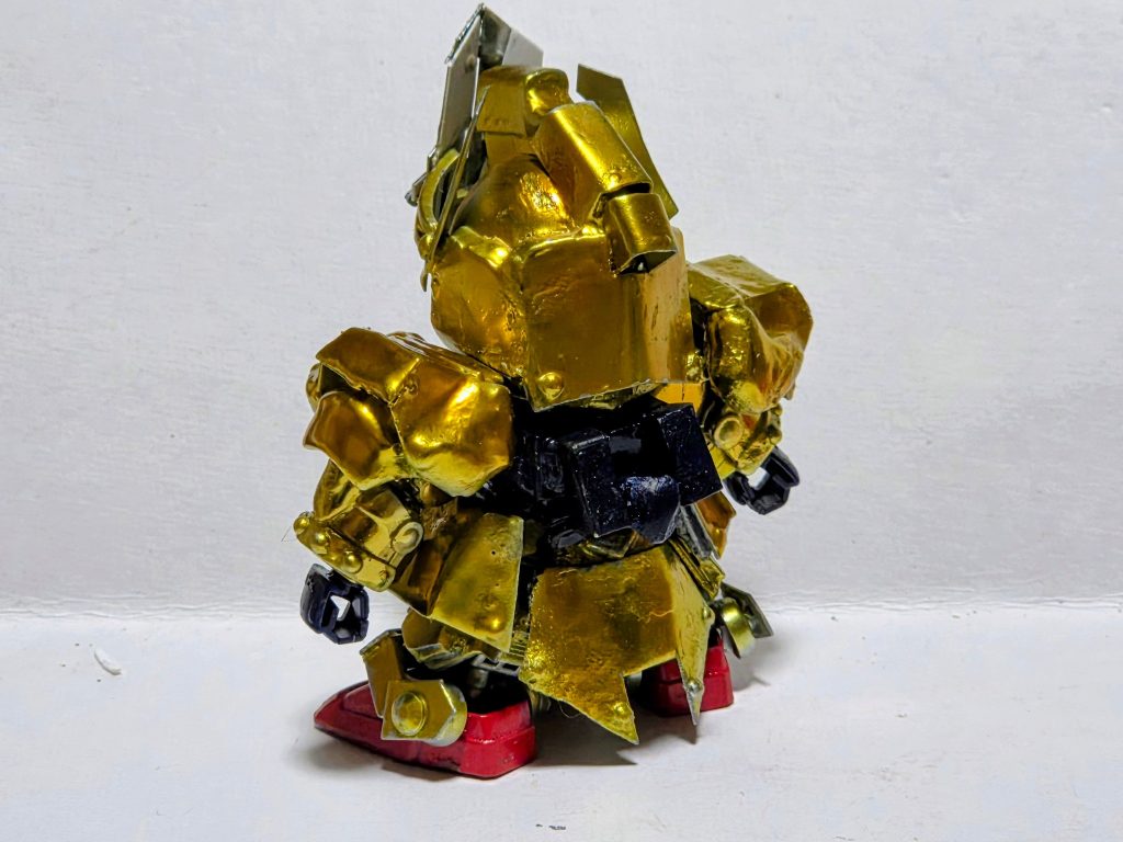 鎧は騎士ガンダムのものをプラ板とパテで加工して制作。剣はナイトソードを削ってパテで形成盾はプラ板で制作。メッキ塗料はモロトフリキッドクロームを1/4の量のうすめ液で希釈して吹いて4日経過後にボーンペイントフィニッシュクリアイエローにクリアレッドを1滴混ぜたものをエア強め、塗料少なめで重ねて吹きかけました。
