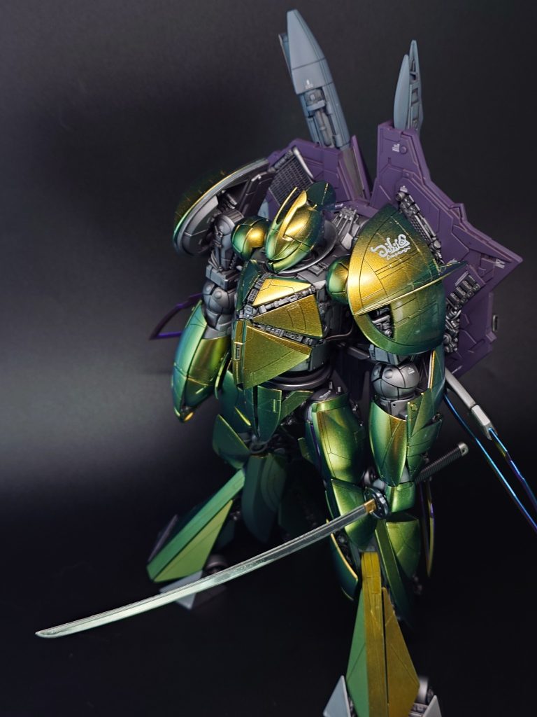 塗装レシピは以下の通り。基本はガイアノーツカラーです。装甲:ムーンゴールドシルバー（下地はクレオスのメタリックグリーン）関節:フレームメタリック2キャラパス:アルカナメタリックパープル武器:ウェポングレー（PLASTICBOMBカラー）羽:モルフォブルー（ストラクチャルフレア）