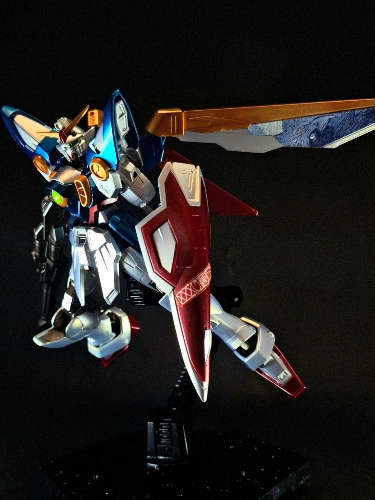 シールドバード形態時の機首を兼ねるガンダニュウム合金製シールド[1]。バード形態時は先端にバスターライフルを接続する。先端部は鋭利で、そのまま打突武器としても使用される[1]。シールド中央部は前後方向に中折れ式の構造となっており、内部にビームサーベルのグリップを一基格納している。テレビ版では先端部にセンサーが設けられているが、EW版では省略されている。