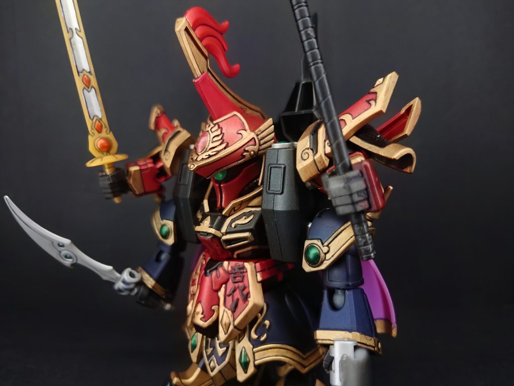 曹操ガンダム：「言われるまでもない！ 我が魂の炎よ、闇を焼き尽くせ！！」劉備と曹操が同時に天へ跳び、それぞれの全闘気を刃に込める！劉備：「星覇龍凰斬（せいはりゅうおうざん）ーーーーッ！！！」曹操：「大紅蓮斬（だいぐれんざん）ーーーーッ！！！」龍と鳳凰の如き光と炎の合体攻撃が、袁紹の四本の腕をすり抜け、その胸の暗黒玉璽へと炸裂する！袁紹（龍飛形態）：「ば、馬鹿な……！？ 私は天に選ばれた名門の帝王……この私が、なぜェェェーーーッ！！」バリバリと音を立てて暗黒玉璽が砕け散ると、袁術の怨念の魂は悲鳴を上げて霧散し、龍飛形態の巨体は激しく爆発。袁紹は自らが呼び出した闇の炎に包まれ、官渡の城の崩壊とともに消え去ったのだった。こうして名門・袁家の野望は、三人の英雄たちの絆によって打ち砕かれた。しかし、玉璽を巡る戦いは、さらなる大戦乱へと突き進んでいくのである……。