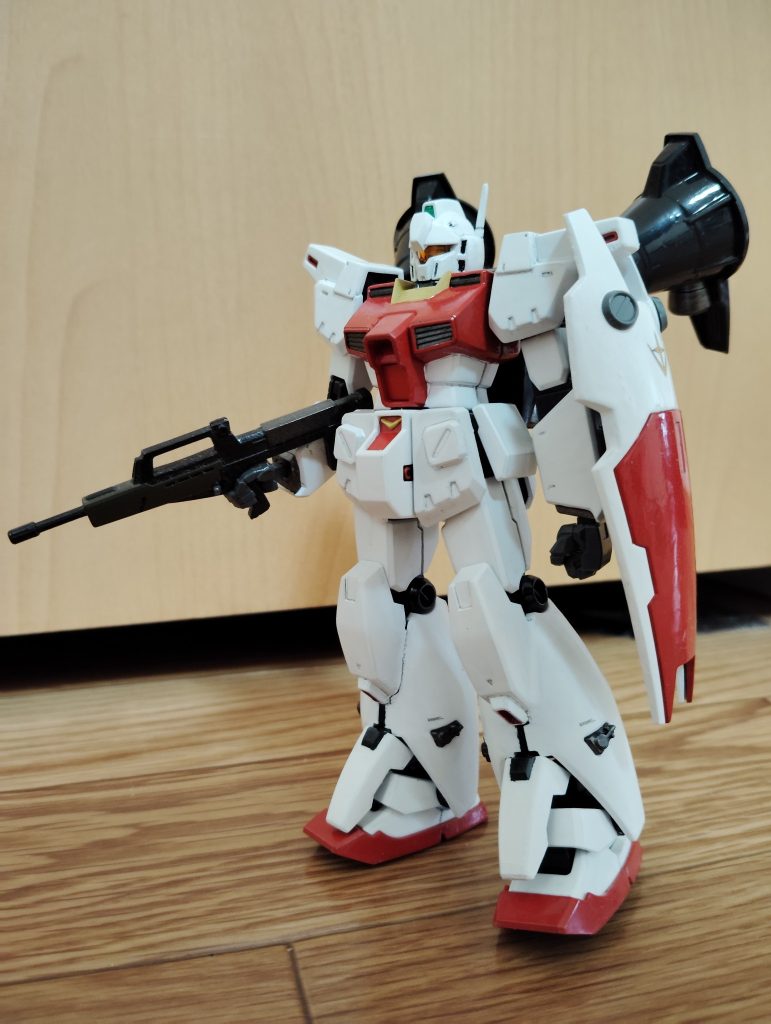 　正面素立ちです。　使用したキットは、HGUCのジム・カスタムとガンダムGP01フルバーニアンです。　ジム・カスタムをベースに、バックパックとスネ部分をフルバーニアンから移植しました。　基本塗装はつや消し白とシャインレッド、襟の部分がクリームイエローです（いずれも水性ホビーカラー）。　また、額のメインカメラは下地を銀色で塗った上から、文房具屋で買ってきた極細タイプのマッキーでグリーンに塗装してあります。　スミ入れは、いつも通りシャープペンです。