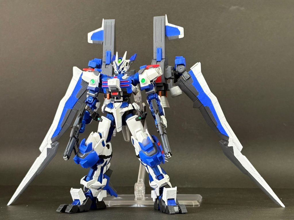 SMF-P03-01-β＋GTW-S047　ガンダムアストレイ ラーズリーフレーム イダテン　ラーズリーフレームを重力下でスタインと戦わせるべく装備を追加した姿。特徴的な背部の二基のエンジンとウイングユニットは、高速飛行用ストライカーパック「イダテン」であり、推進剤を消費しない特殊推進機構を持つ。さらに、安定した空中戦を展開できるよう、補助アーマー「ヌーベース」を追加。これらは従来のスラスターに加え、擬似反重力機関「レヴィテータ」を内蔵しており、重力圏で優れた浮遊・機動能力をサポートする。　見た目通りの設定ですね。イダテンはテルティウムのブースターをベースに、RGジャスティスとフリーダムの羽をウイングにしています。実写のジェットウイングを見てもらえると分かると思うのですが構成はほとんどそのままです。　足、胸、頭はアスモデウスのパーツを加工して装着しています。アスモデウスはブルーに絶対合うと思ってたので、個人的には大満足ですね。