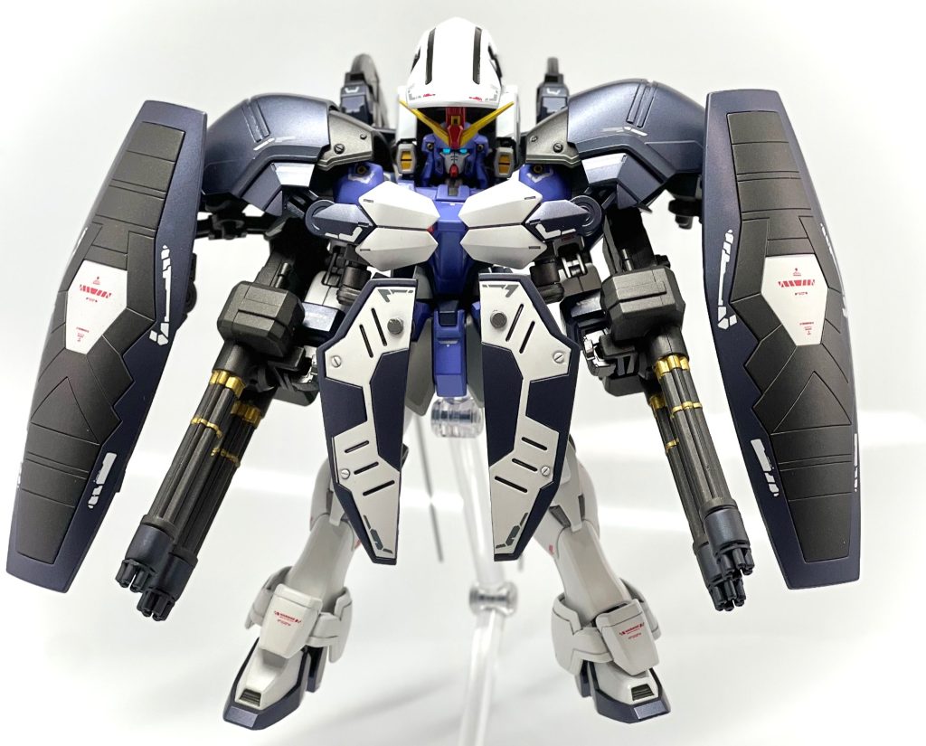 サンドロック改EWをベースに、アーマディロの代名詞ともいえるマグアナックの盾を装備。腰部分の装甲は旧1/144サンドロックカスタムの盾を半分に切って使用しています。また、頭部分が手薄に感じたんでヘッドガードにはガンダムグレモリーを使用しました。装甲で身を固めながら突撃するなら面制圧に優れた武器が必要だなと思い旧1/144ヘビーアームズカスタムのガトリングをそのまま持たせてみました。カトルが知る中で最も面制圧に優れた武装といわれたら真っ先にヘビーアームズが思い浮かぶだろうと思い装備した次第です。