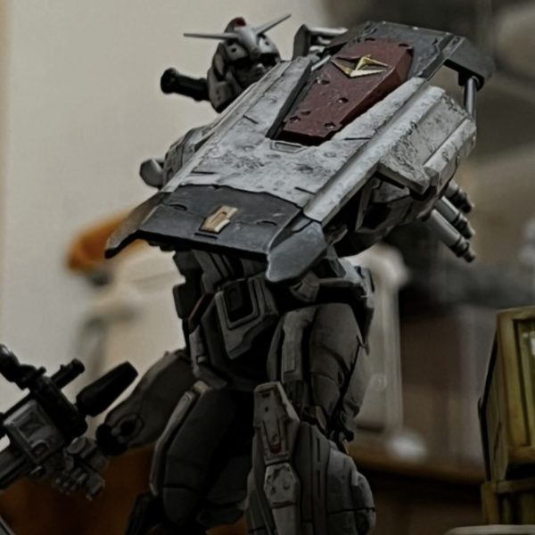 サムネのガンダムの背後からコンテナ越しにイリア・ソラリのザクがヒートホークで飛び掛かる瞬間を捉えたイメージでおります。ジオラマのレイアウトを調整しながら追加で必要と思われる小物をせっせと作ってます。ベースのサイズに合わせてちょっとした作業小屋を追加。その脇にトラック2台。その内の1台はオープントップにして荷台にマゼラの砲身を2本載せてます。（劇中でもそんなシーンがありました）自衛隊のトラックにジオンマーク！似合います😅ガンダムのシールドにはリューターでダメージ加工を施してザクマシンガンの弾痕をば表現。廃車も良い感じですがブレーキランプ等はしっかり塗装した方が良さそうです。コンテナは白の下の赤にも衝撃が伝わり下が少し浮き上がった状態にしています。その隙間からホコリが出ている表現を真綿で出来たら面白いと思っています。（2枚目）