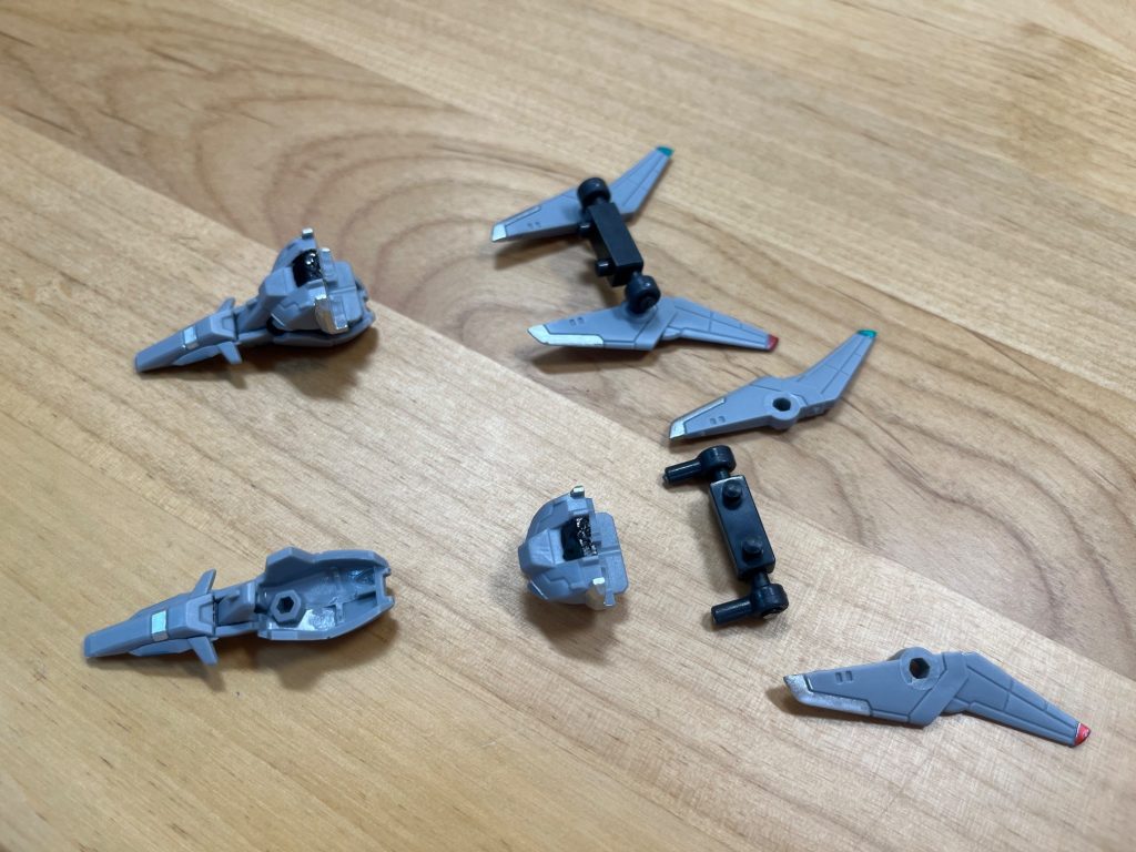盾の隙間にうまいことコックピットハッチを差し込みます。切った十字の部分に胸部パーツを差し込みます。ジャストフィットしたら完璧です。次にバックパックの軸に肩関接を差し込みます。差し込んだ肩関節の軸につばさを差し込みます