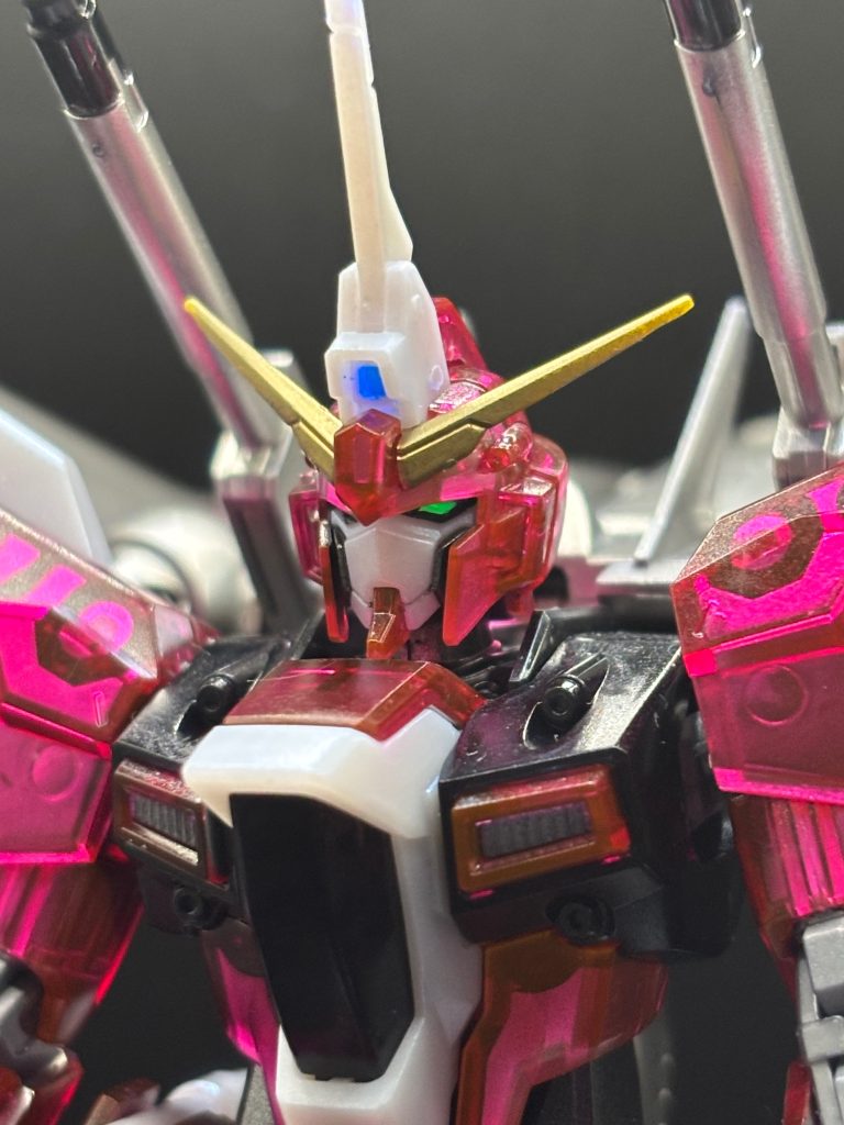 顔のアップです。まぁイケメンですこと(zaku-kao6)❗️組み立て説明書では一番最初に組むことになるのが、ヘッドパーツなのです。カッコよくて始めからテンション上がりました✨ツインアイはなんとデフォルトでブラックライトで光るんです👀✨ただ、残念なのはほぼ全身のクリアレッドパープル部分がブラックライトに反応してオレンジに発光してしまうため、撮影の際に余計なところが光らないように光源調整が激ムズでした💧撮影難易度★★★★★※個人の感想です。