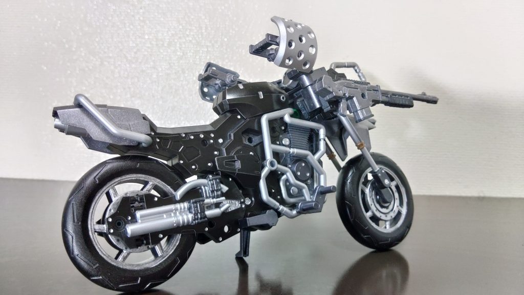 後ろ姿。元々前傾姿勢で乗るバイクを無理やりゆったり姿勢で乗るように少し弄った結果、少々歪なフォルムになりました。マフラーに使われているパーツは王様戦隊キングオージャーのキングコーカサスカブトの余った煙突パーツがなんと無加工で取り付けることができました！車両名の由来はガンダムルブリス・クロスガンズの元ネタになったニコラスDウルフウッドの師匠の名前から取りました。