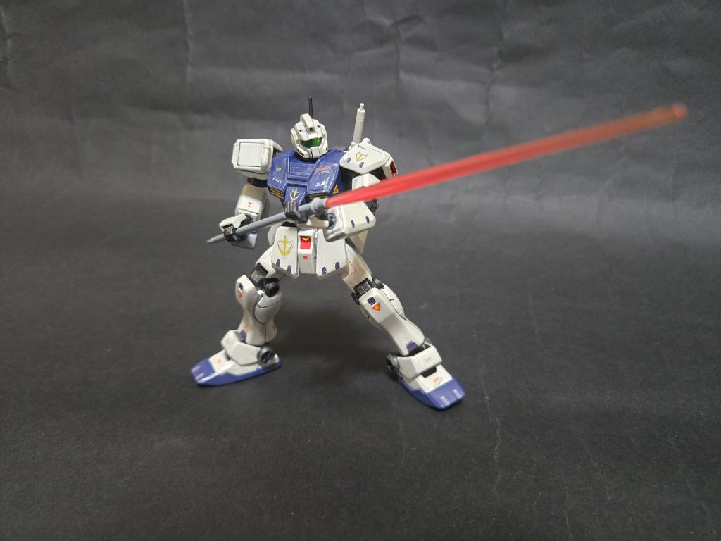 試作ビームスピア RX-78-2のビームサーベルの、ビームジャベリンへの伸縮機構を参考に試作された武装。本機のものは伸縮機構はオミットされており、単純にビームサーベルのグリップを長くしたものだが、白兵戦において一定の有用性があることが確認されている。ランドセルの背面にマウントラッチを持つ。
