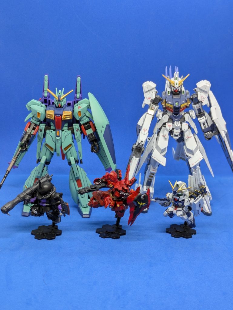 サイズ比較。後ろにいるのは一般的なサイズのHG(ジリウス)と、GフレームFAのリ・ガズィカスタムです。比べるとだいぶ小さいのが分かると思います。余談ですが、リ・ガズィカスタムもスミ入れ、部分塗装してつや消し吹いています。ご覧いただきありがとうございます。
